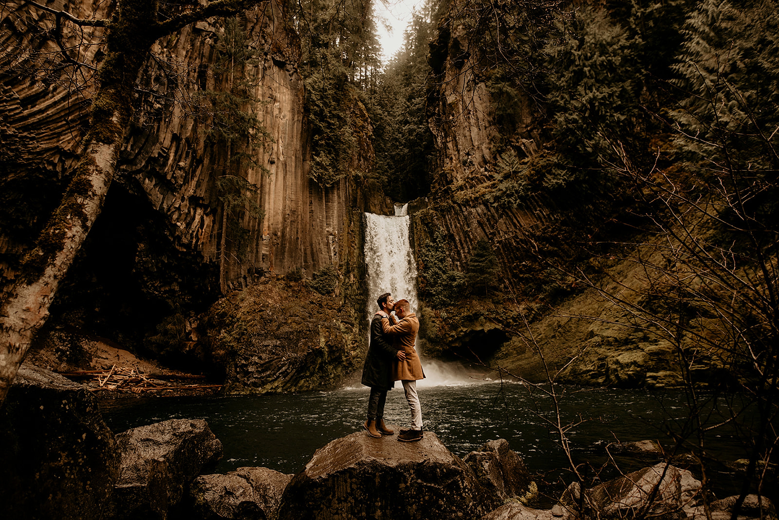 couple hugging in front of toketee falls