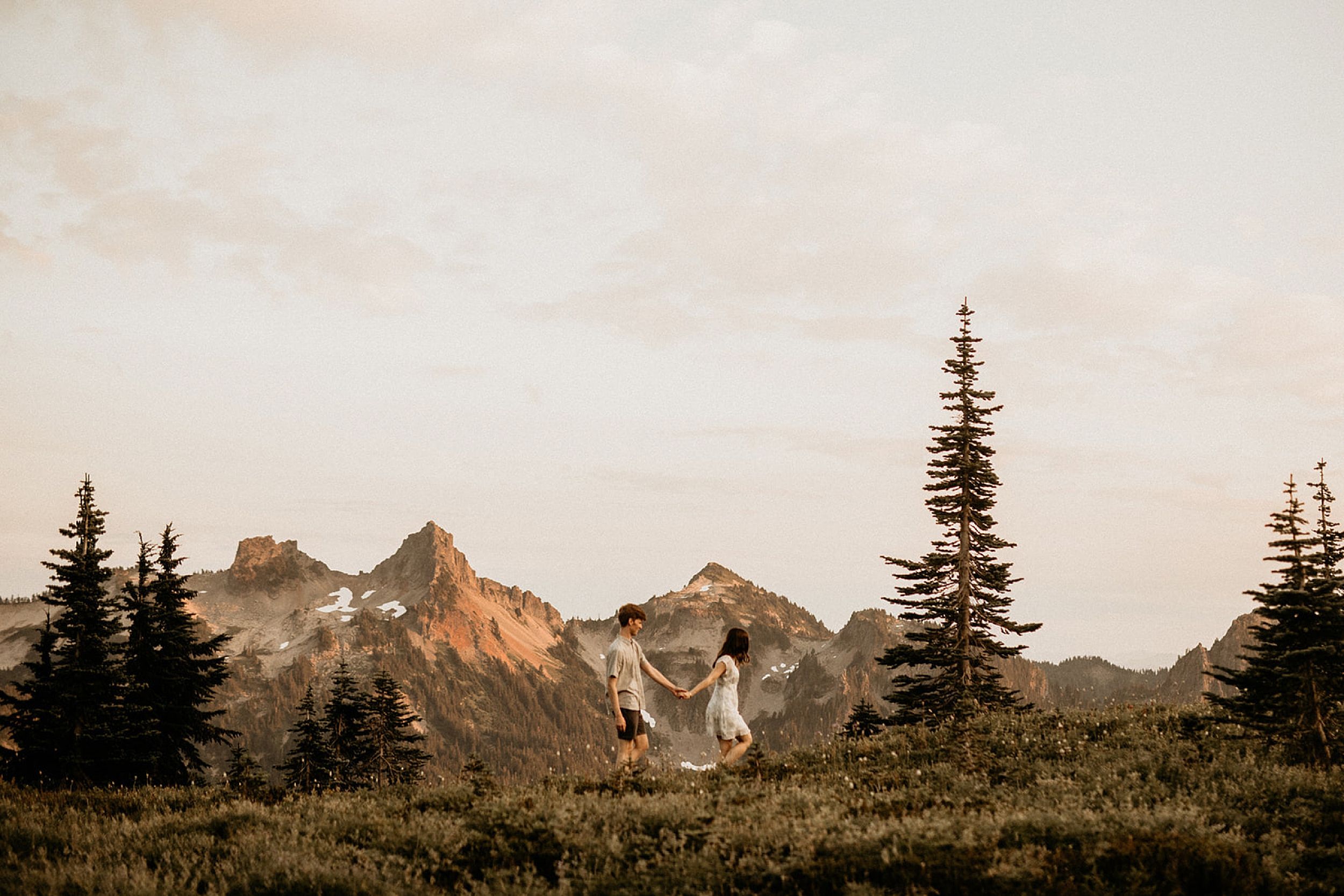couple walking in front of mountains 