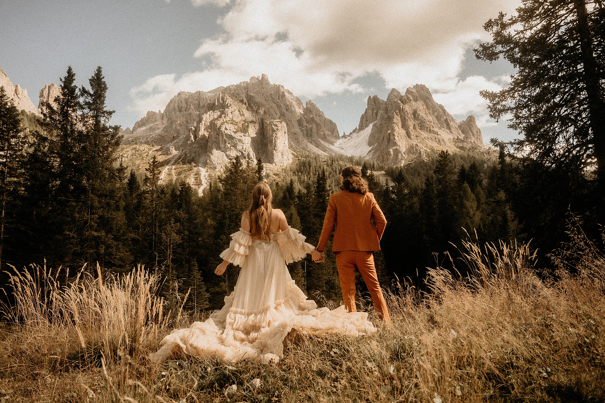 bride and groom holding hands dolomites landscape

