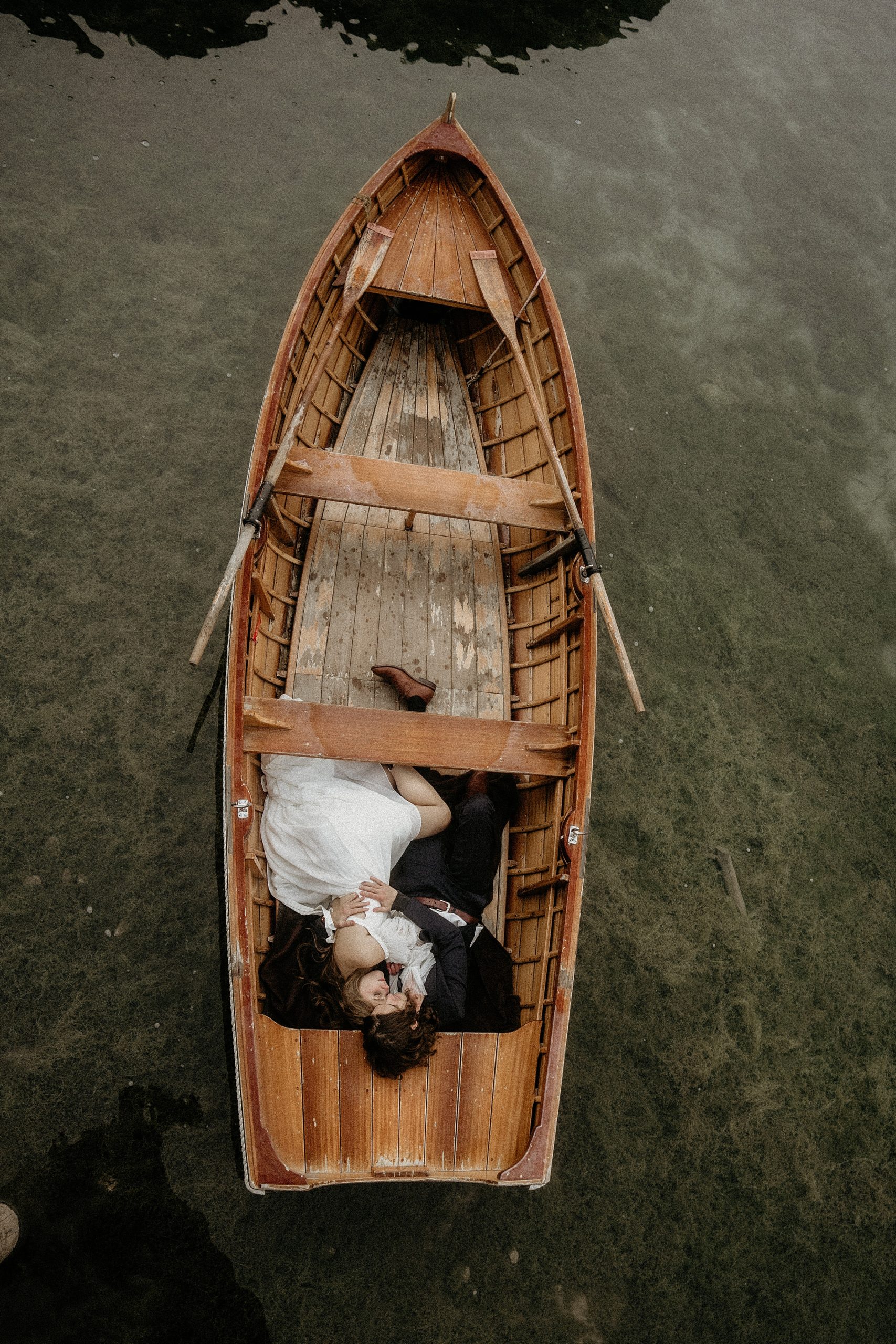 bride and groom holding each other in boat
