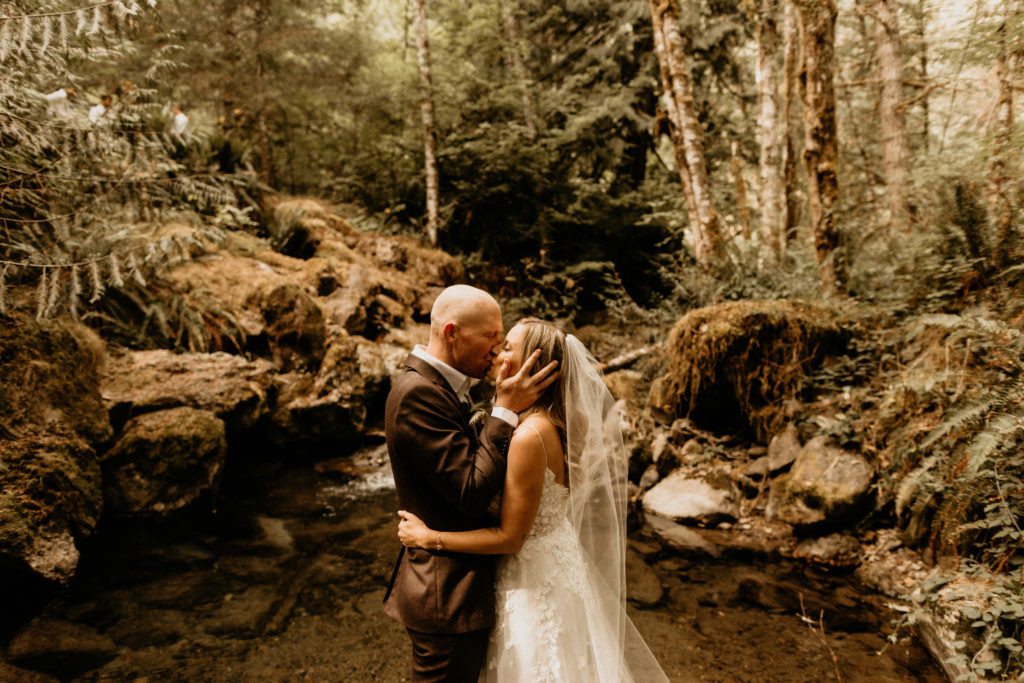 bride and groom kissing forest landscape