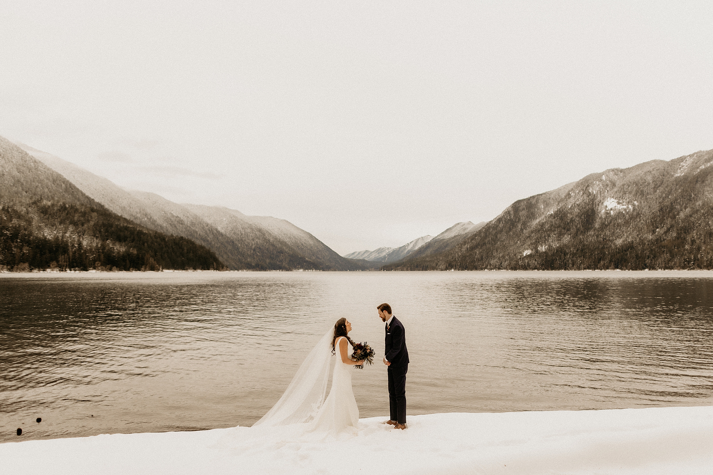 bride and groom standing together lake crescent snow landscape 

