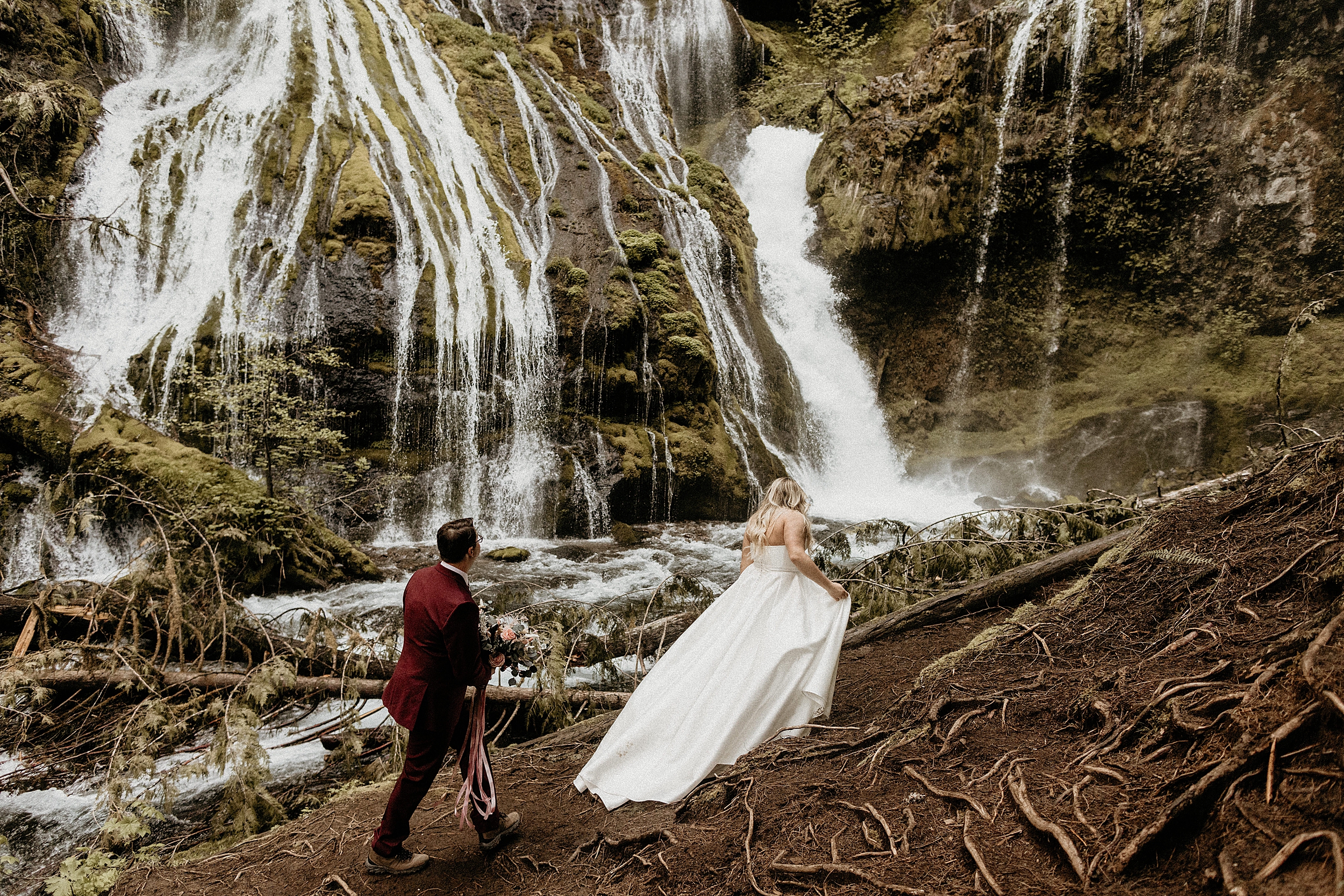bride and groom walking together waterfall landscape