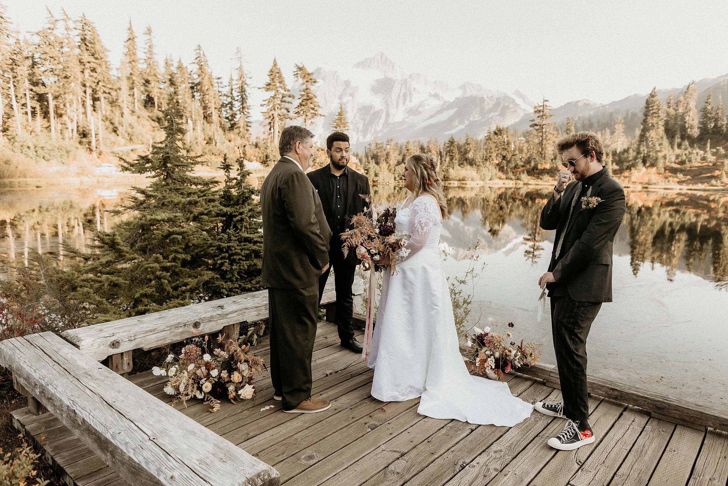 bride and groom standing together on dock north cascades national park landscape
