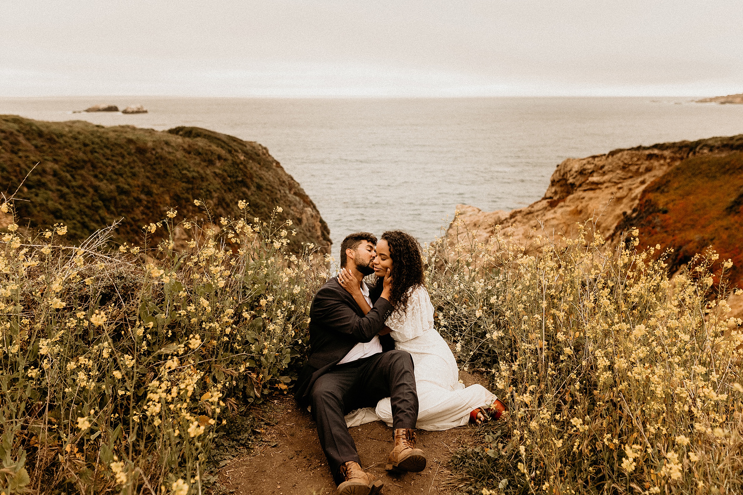 bride and groom kissing ocean view landscape