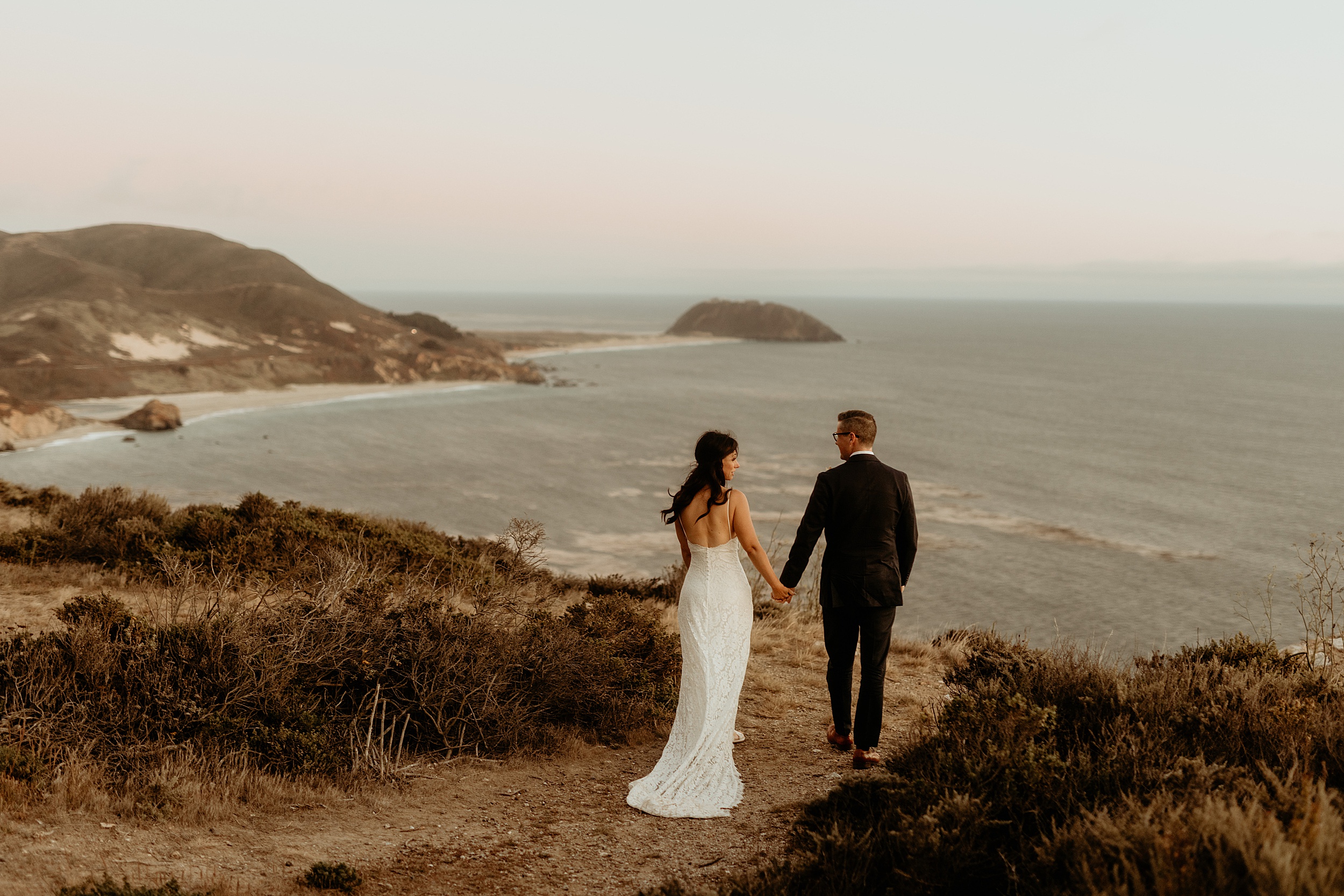 bride and groom holding hands ocean view big sur landscape