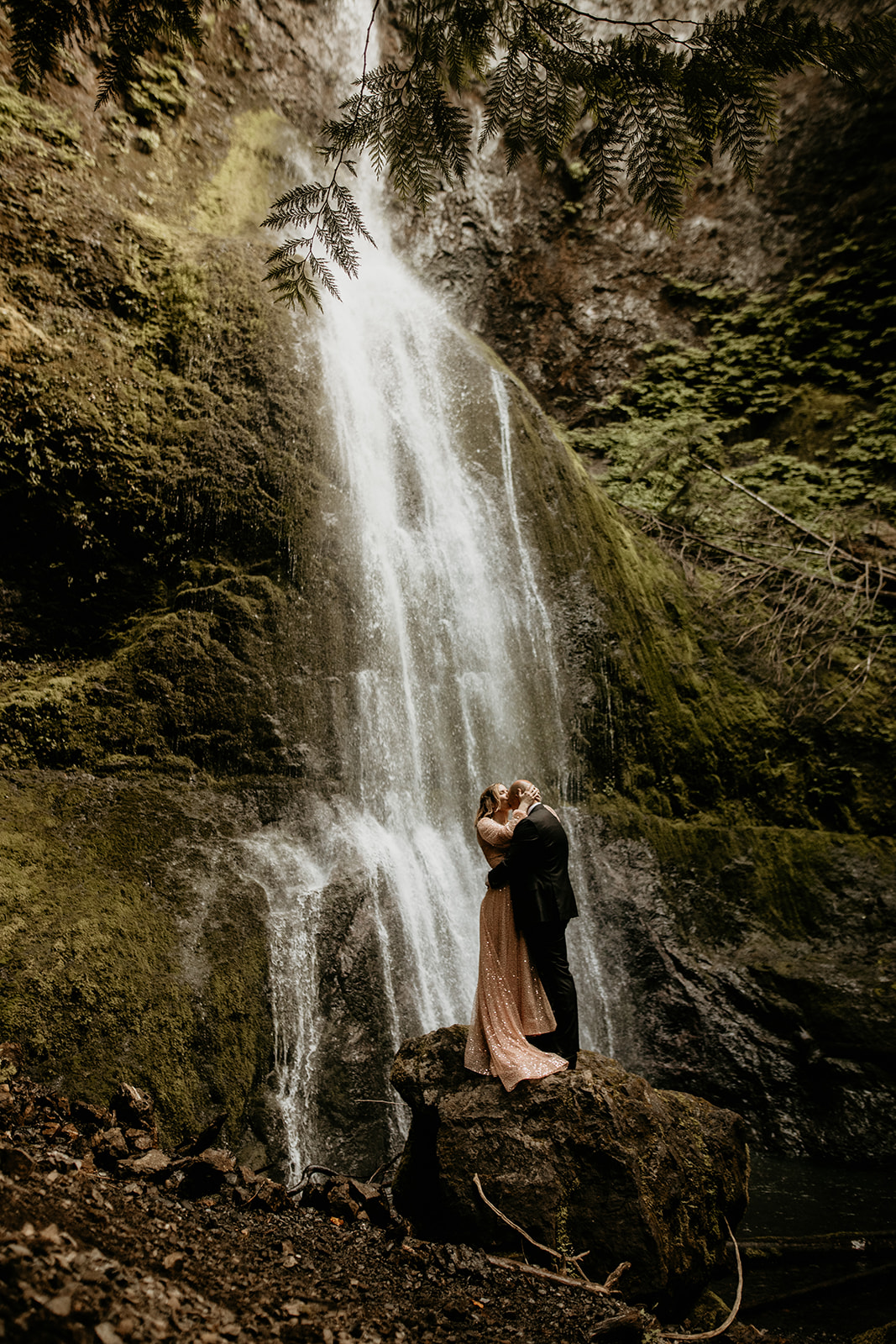couple kissing near water fall 