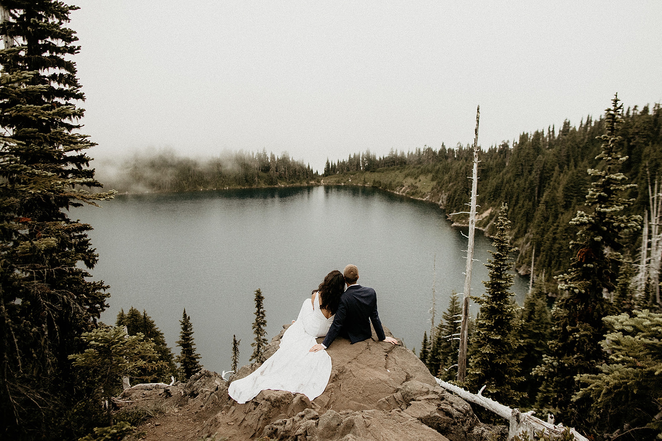 bride and groom sitting together forest landscape