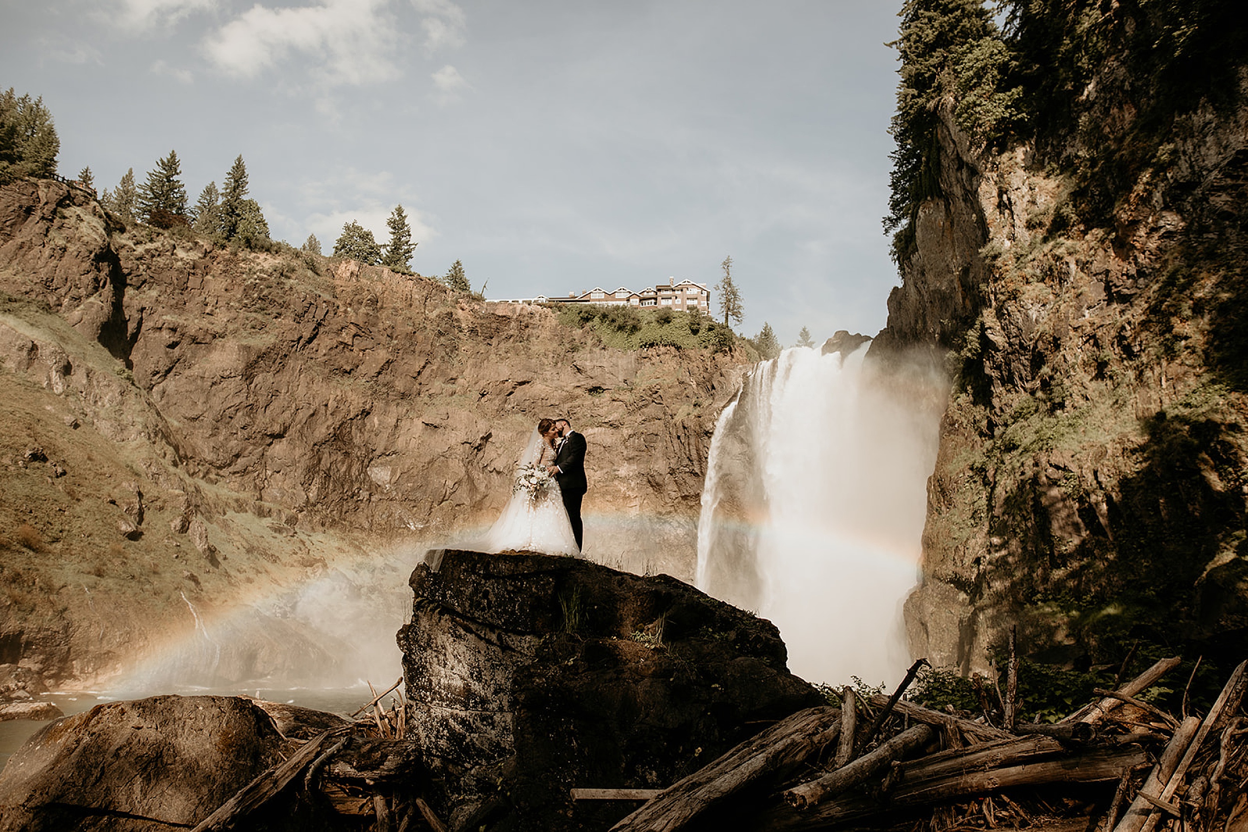 bride and groom standing near waterfall 